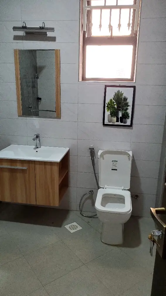 Plumber unblocking clogged drain in residential Kampala property